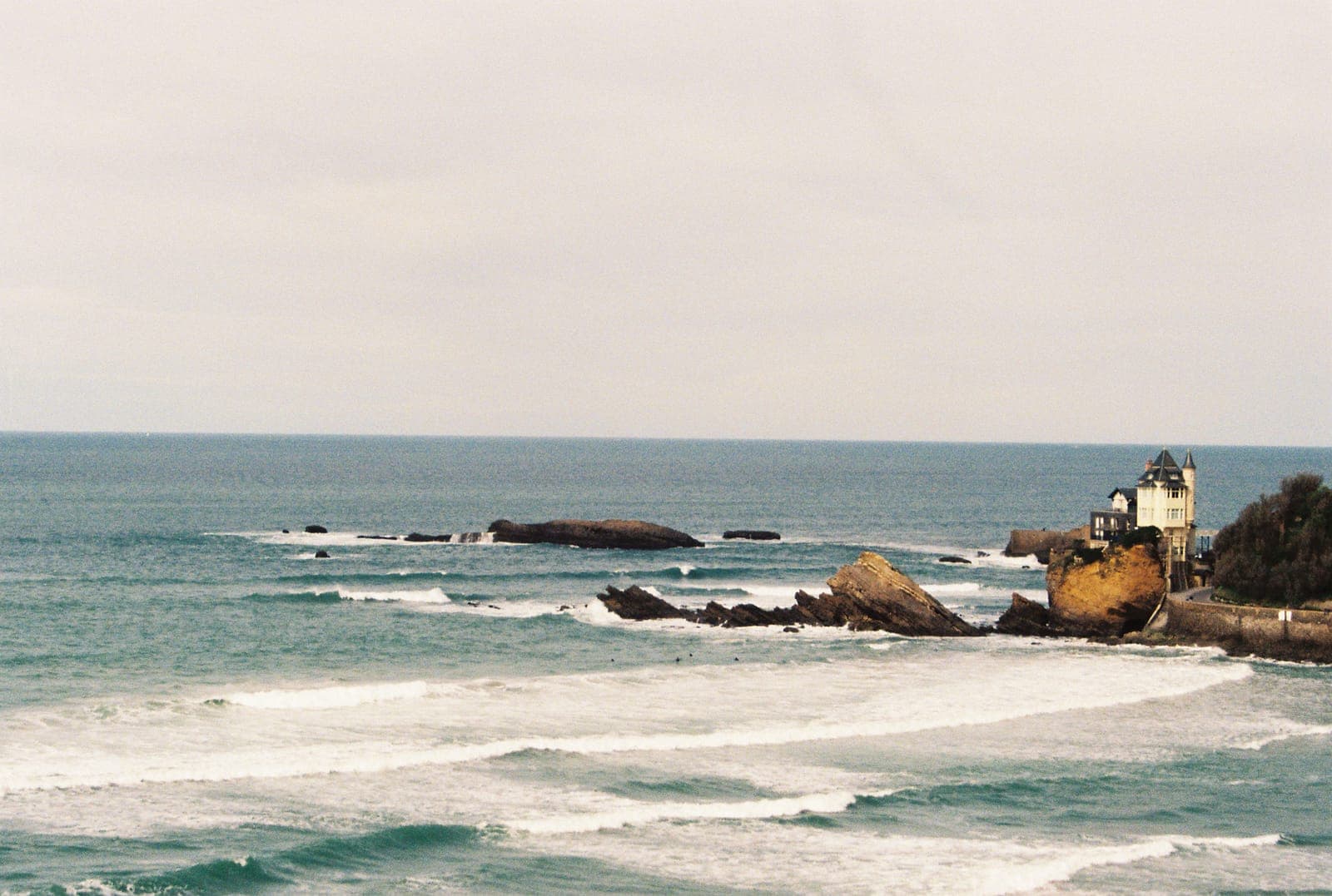 waves breaking around rocks offshore