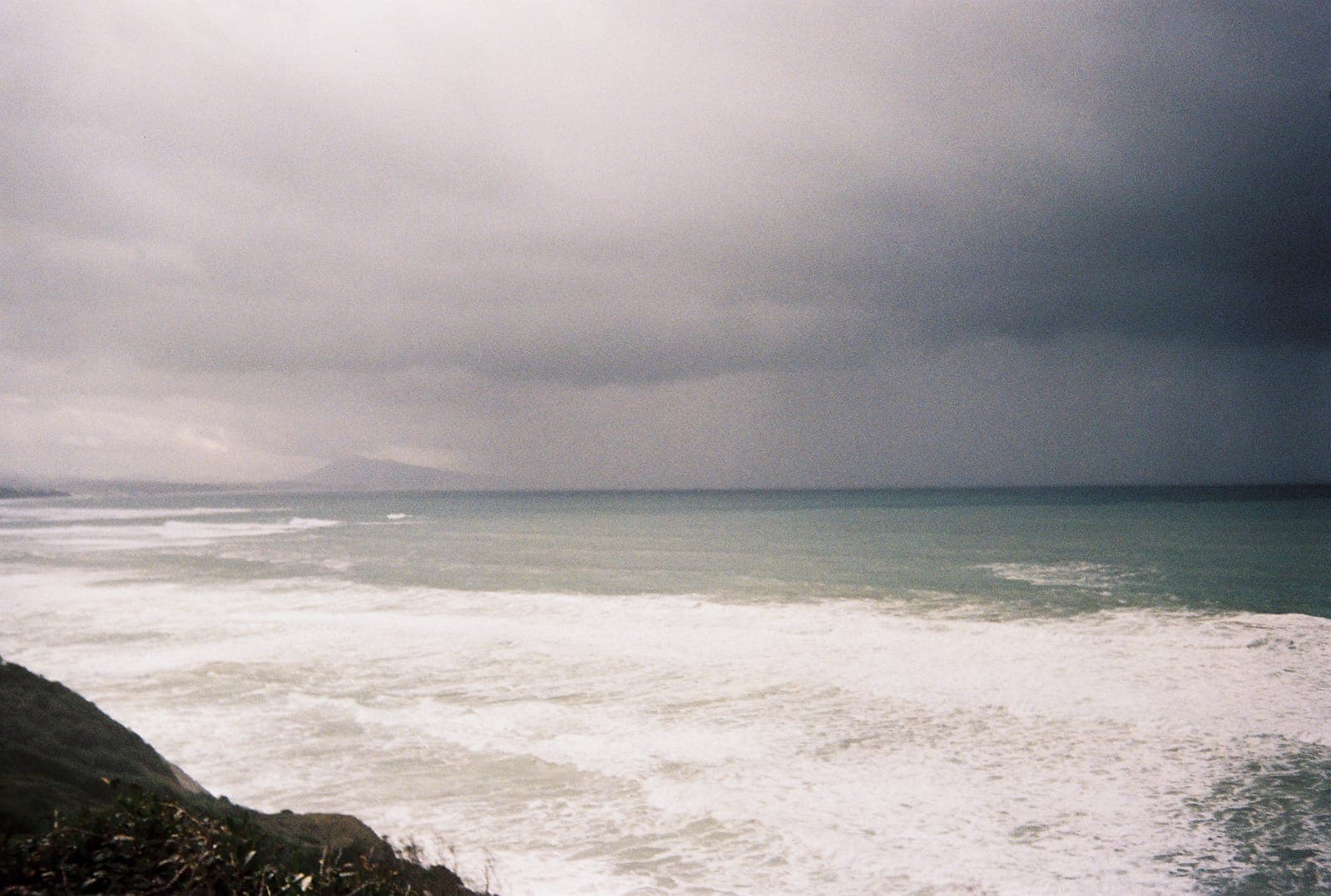 storm cloud dragging rain over the sea