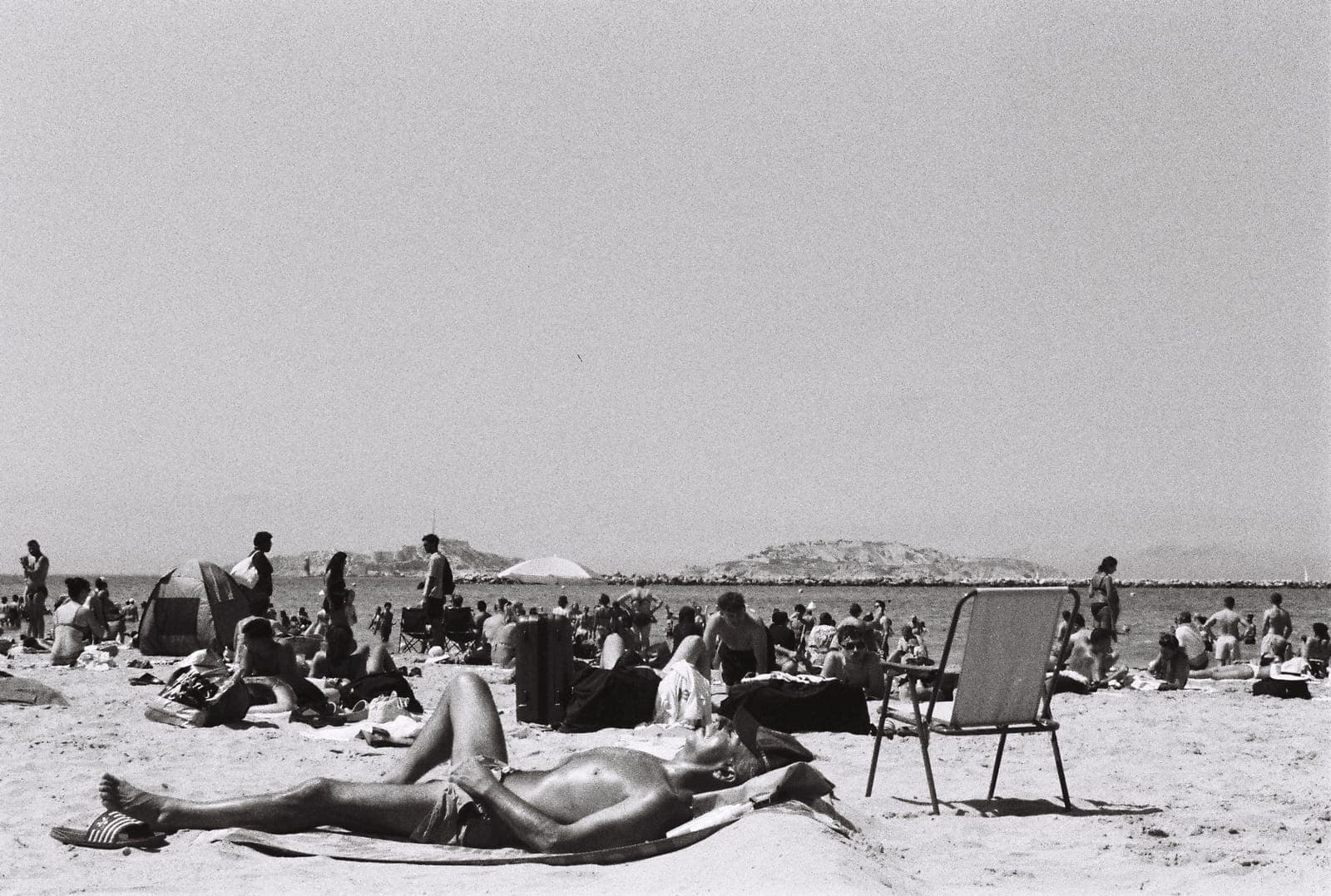 sunbathers on a packed beach, in black and white