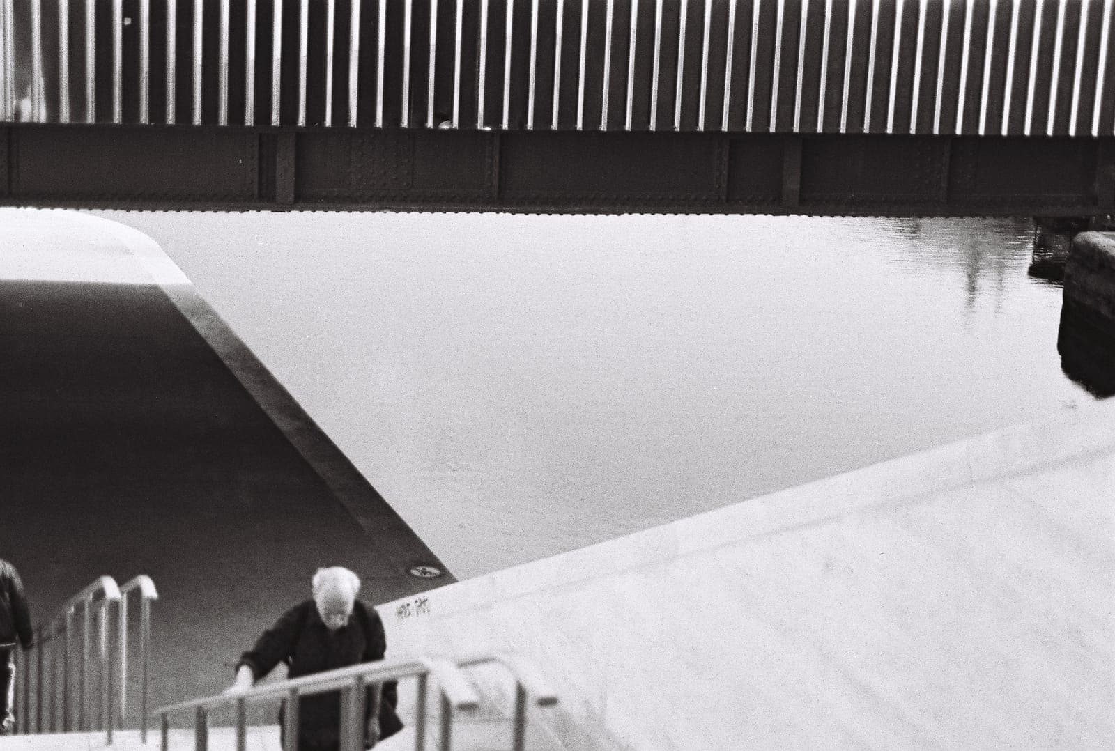 figure on the steps of a geometric building, in black and white