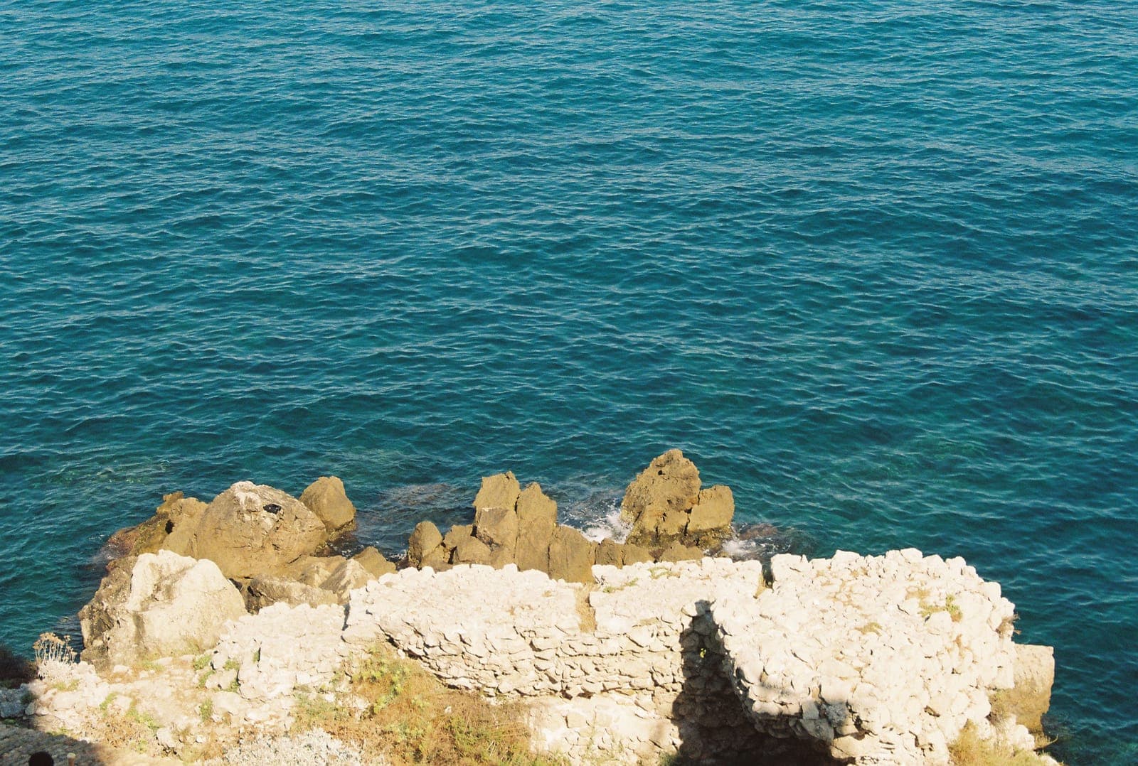 turquoise sea beyond stone ruins